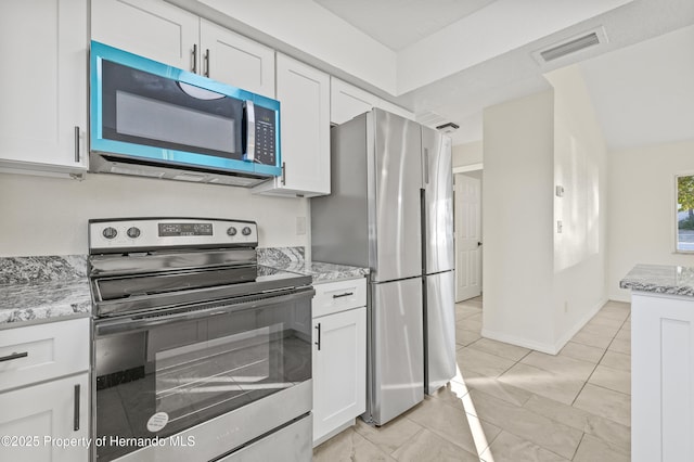 kitchen with white cabinetry, light stone counters, and appliances with stainless steel finishes