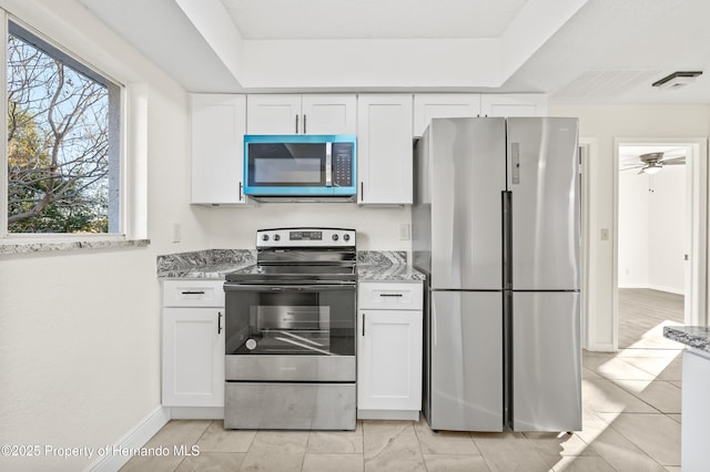 kitchen with white cabinetry, light stone countertops, and stainless steel appliances