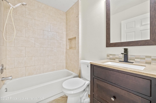 full bathroom with tasteful backsplash, tiled shower / bath, vanity, and toilet