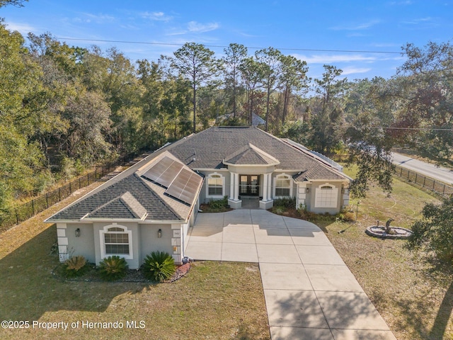 view of front of house with a front lawn and solar panels