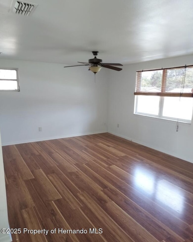 spare room featuring dark wood-type flooring and ceiling fan