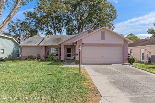 ranch-style house featuring a garage and a front lawn