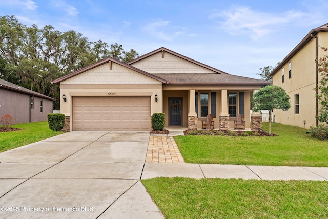 view of front of property with a garage, covered porch, and a front yard