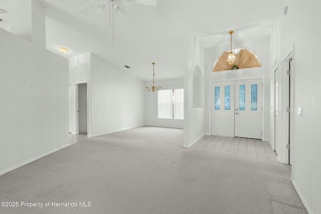 foyer featuring light carpet, vaulted ceiling, and baseboards