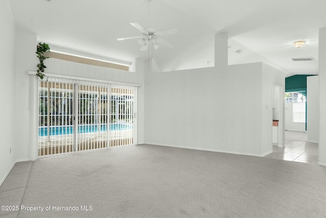 spare room with light tile patterned floors, light colored carpet, visible vents, vaulted ceiling, and ceiling fan