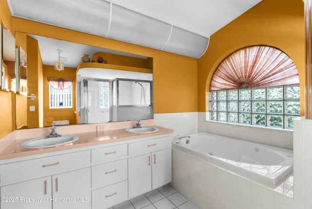 bathroom featuring double vanity, a stall shower, tile patterned flooring, and a sink