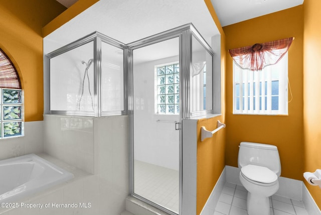 bathroom with tile patterned flooring, baseboards, a shower stall, and toilet