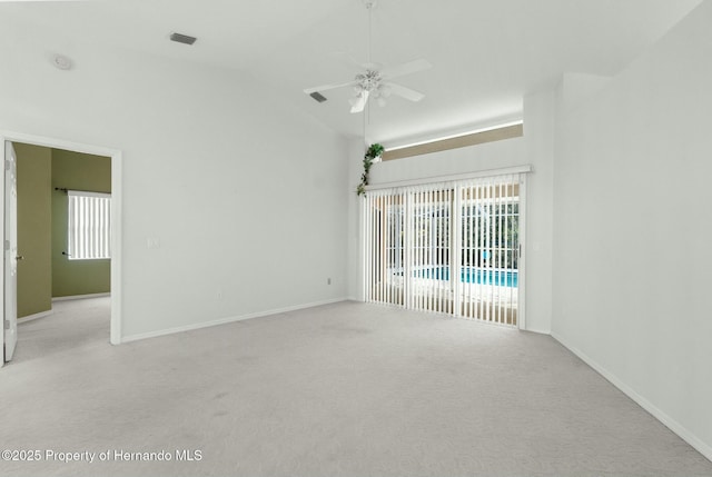 empty room featuring baseboards, plenty of natural light, a ceiling fan, and light colored carpet