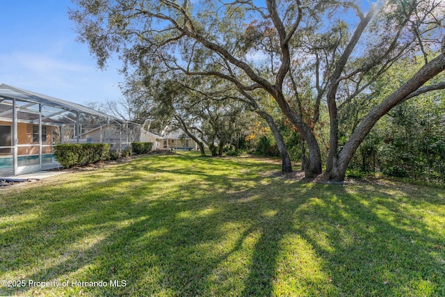 view of yard with a lanai and an outdoor pool