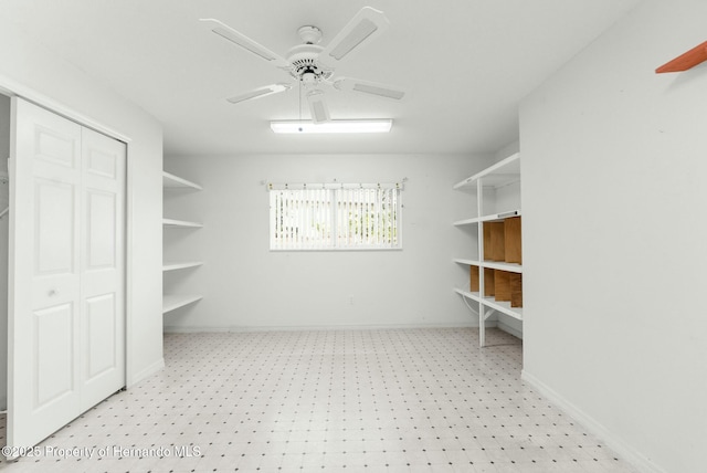 spacious closet with light floors and ceiling fan