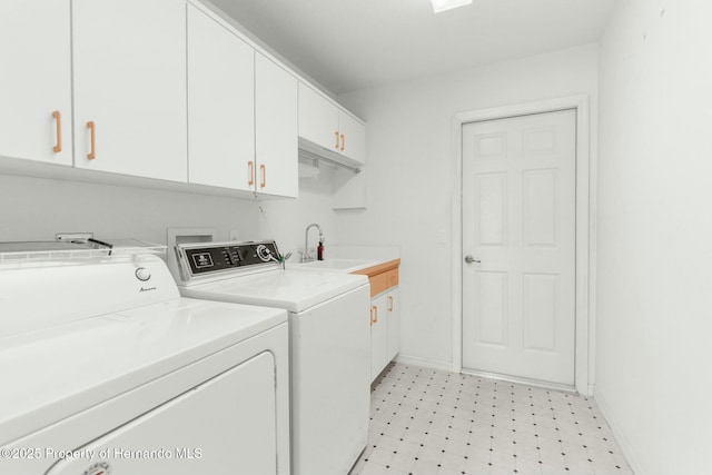 clothes washing area with cabinet space, baseboards, light floors, and washer and dryer