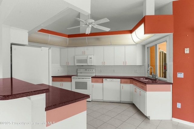 kitchen featuring white appliances, backsplash, a sink, and white cabinetry