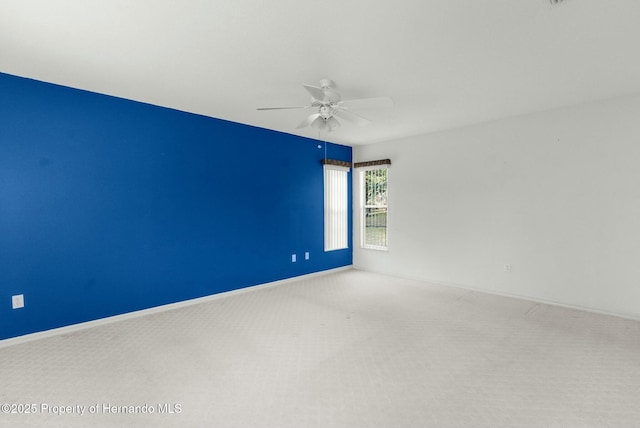 empty room with carpet, baseboards, and ceiling fan