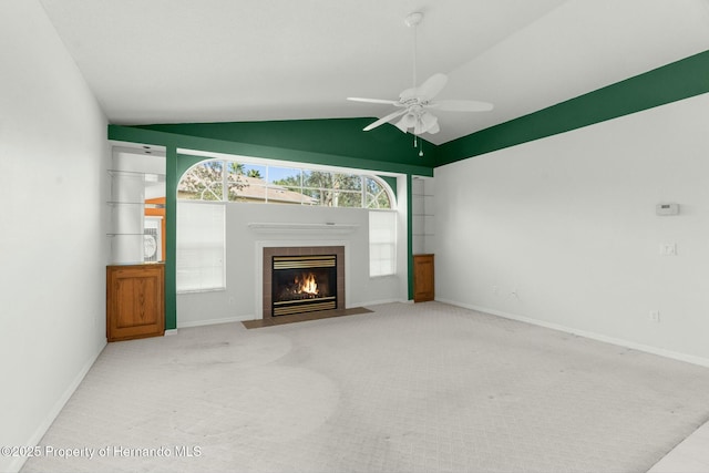 unfurnished living room featuring lofted ceiling, light carpet, a ceiling fan, baseboards, and a tiled fireplace