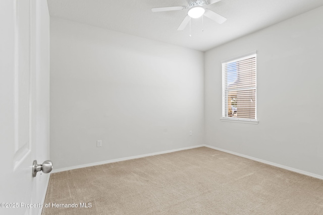 carpeted spare room with ceiling fan