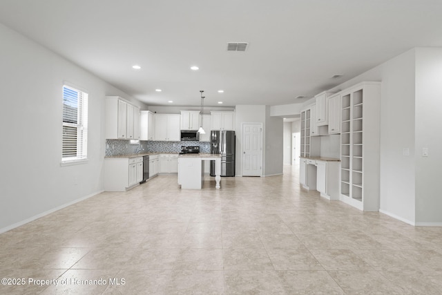 kitchen with pendant lighting, appliances with stainless steel finishes, backsplash, white cabinets, and a kitchen island