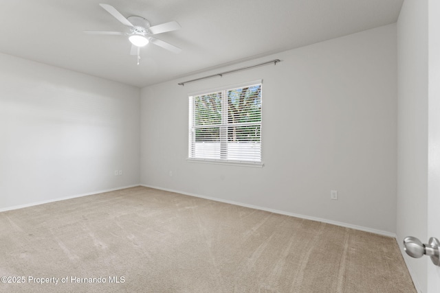 carpeted spare room with ceiling fan