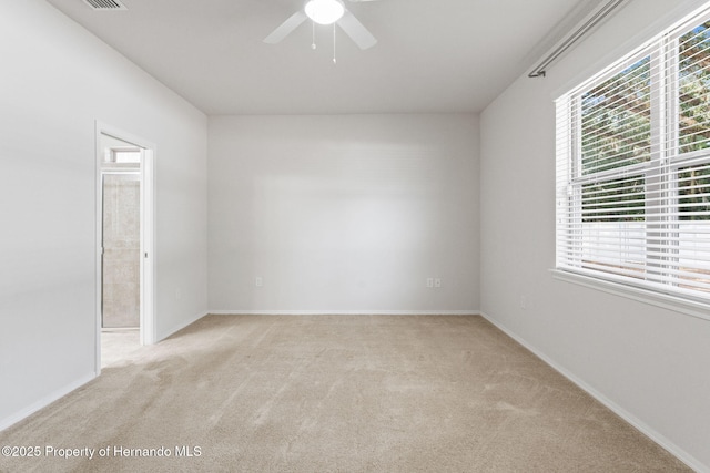 carpeted spare room with ceiling fan