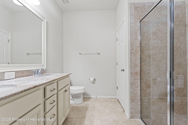 bathroom featuring vanity, toilet, and a shower with door