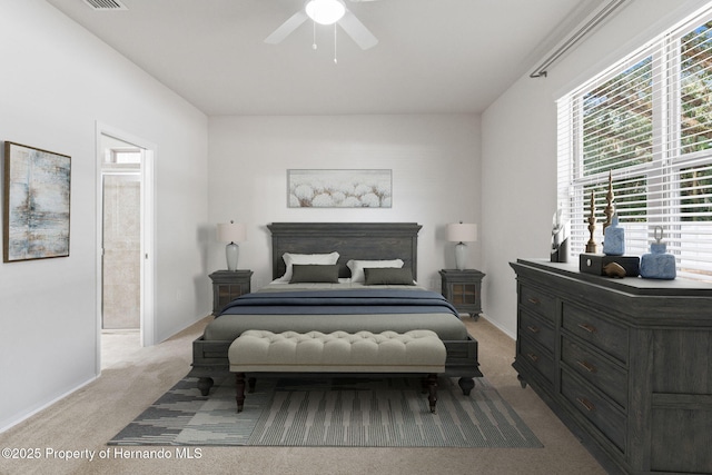 carpeted bedroom with ceiling fan and ensuite bath