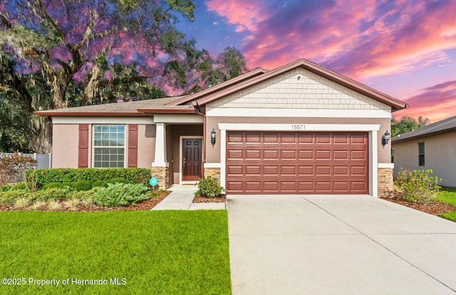 15571 Stone House Dr, Brooksville, FL 34604 - view of front of home with stone siding, an attached garage, a yard, driveway, and stucco siding