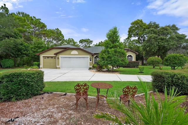 single story home featuring a garage and a front lawn