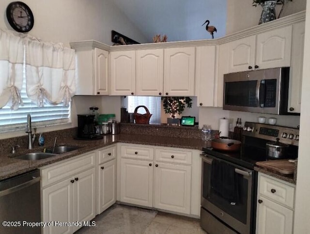 kitchen featuring white cabinetry, lofted ceiling, appliances with stainless steel finishes, and sink