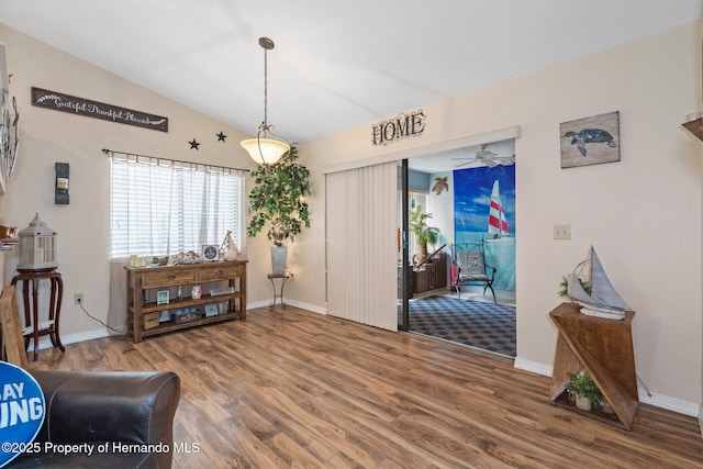 living area featuring lofted ceiling and hardwood / wood-style floors