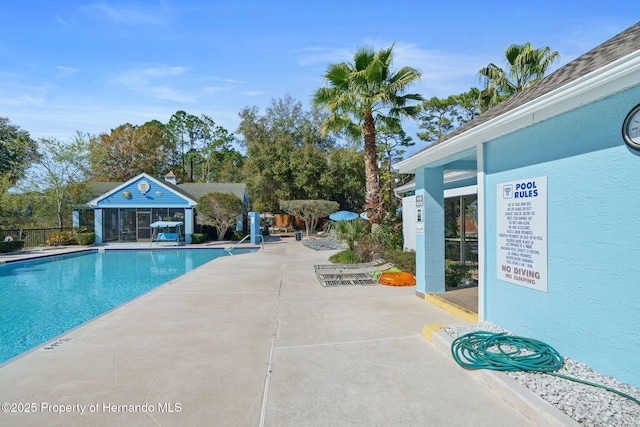 view of pool with an outbuilding and a patio area