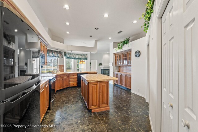 4412 Lake In The Woods Dr, Spring Hill, FL 34607 - kitchen featuring recessed lighting, a peninsula, a center island, wooden counters, and black appliances