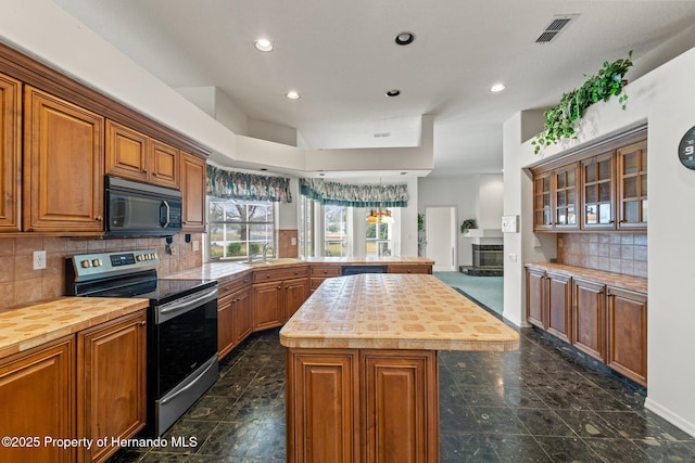 4412 Lake In The Woods Dr, Spring Hill, FL 34607 - kitchen featuring black microwave, electric range, a peninsula, visible vents, and butcher block countertops