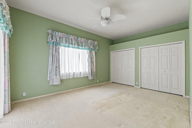 4412 Lake In The Woods Dr, Spring Hill, FL 34607 - unfurnished bedroom with ceiling fan, baseboards, two closets, and carpet floors