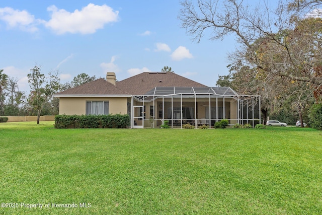 4412 Lake In The Woods Dr, Spring Hill, FL 34607 - rear view of house with a lanai, a yard, stucco siding, and a chimney