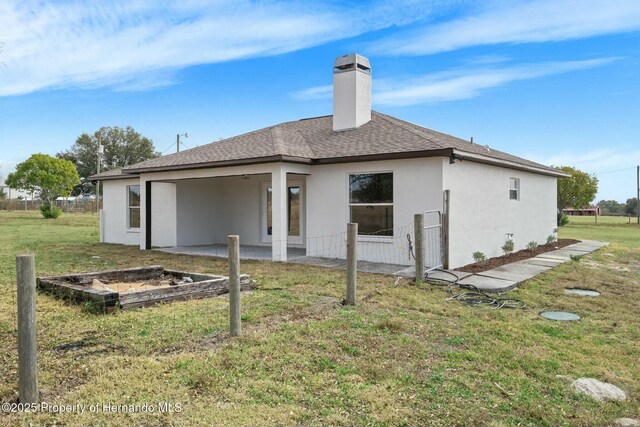 back of house featuring a lawn and a patio area