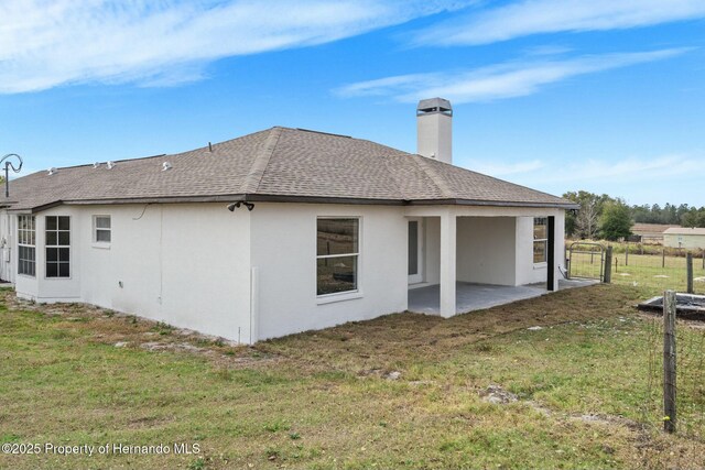 rear view of property with a lawn and a patio