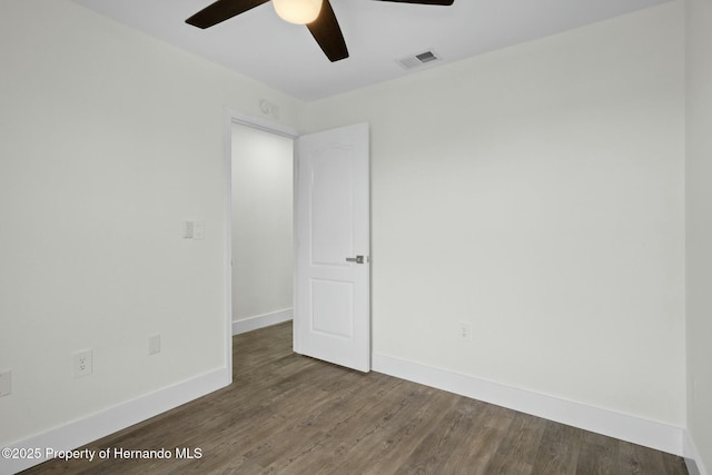 empty room featuring ceiling fan and dark hardwood / wood-style flooring