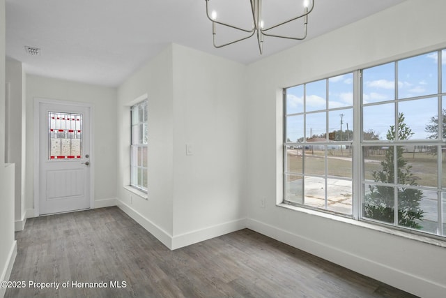 unfurnished dining area with hardwood / wood-style flooring and a chandelier