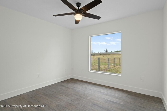 empty room featuring ceiling fan and dark hardwood / wood-style flooring