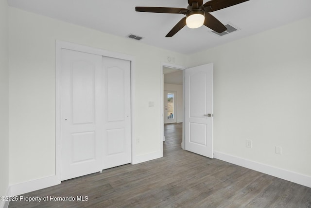 unfurnished bedroom with hardwood / wood-style flooring, a closet, and ceiling fan