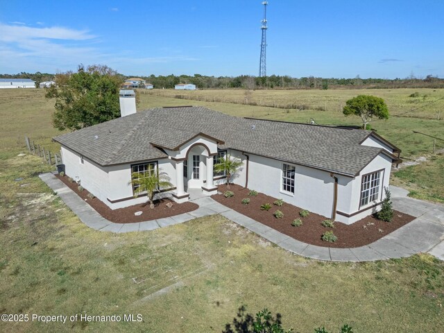 view of front of house featuring a rural view and a front lawn