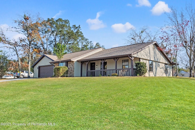 view of front of home featuring a porch, a garage, and a front yard