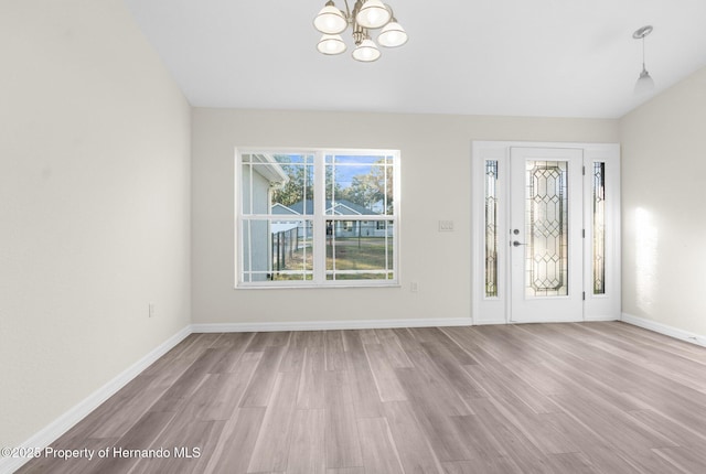 foyer entrance featuring an inviting chandelier and light hardwood / wood-style flooring