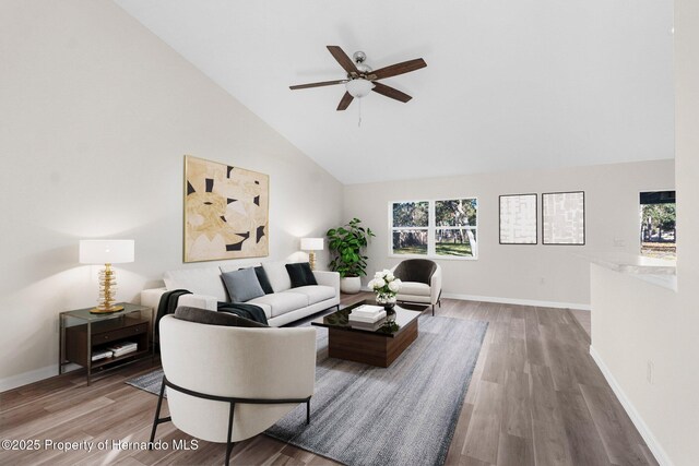 living room featuring hardwood / wood-style flooring, ceiling fan, and high vaulted ceiling