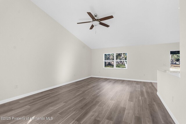 unfurnished living room featuring ceiling fan, dark hardwood / wood-style floors, and high vaulted ceiling