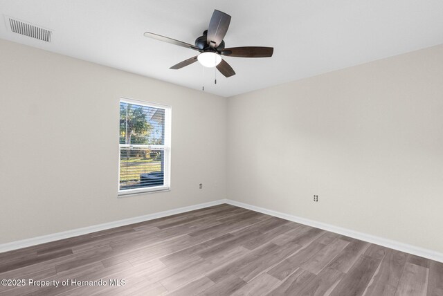 spare room with hardwood / wood-style floors and ceiling fan