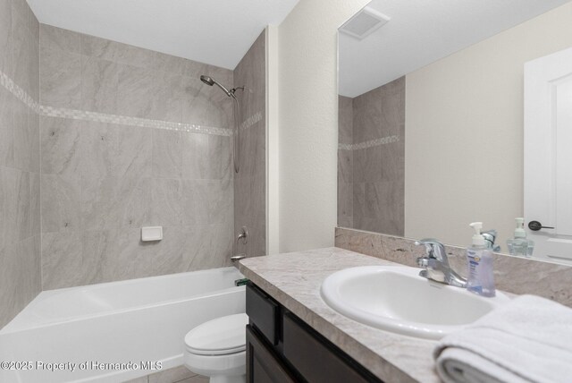 full bathroom featuring vanity, toilet, and tiled shower / bath combo