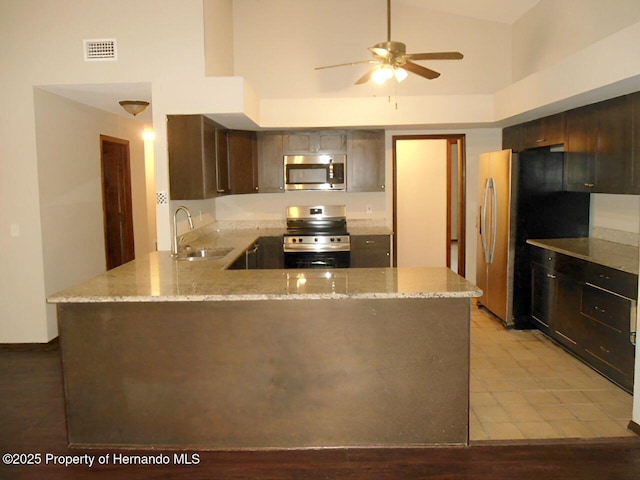 kitchen featuring sink, ceiling fan, appliances with stainless steel finishes, dark brown cabinets, and kitchen peninsula