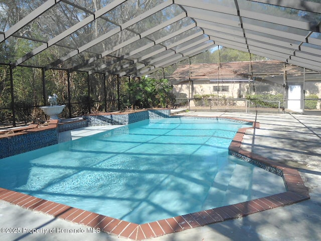 view of pool with a patio and glass enclosure