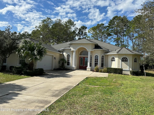 view of front facade featuring a garage, a front lawn, and french doors