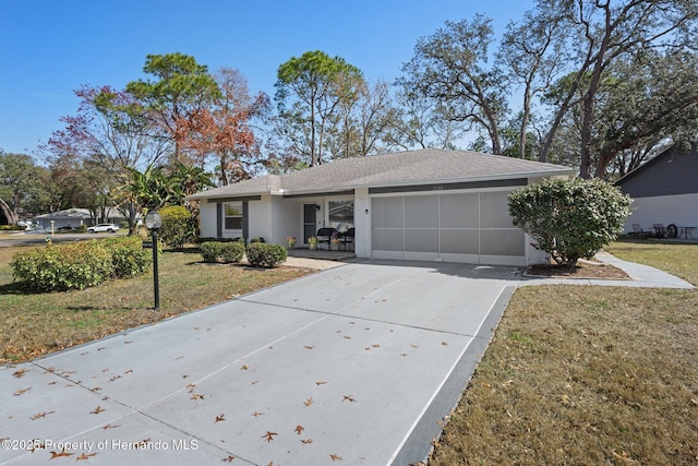 single story home with a garage and a front lawn